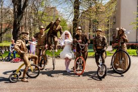 Grupa rowerzystów w przebraniach, kobieta w sukni panny młodej - rowerowa impreza plenerowa